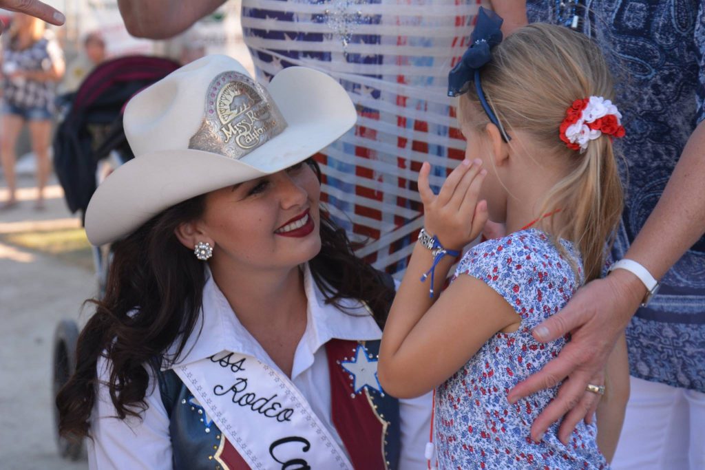 Miss Rodeo California, Rachel Owens Sarno, talking with a young lady about her favorite part of rodeo.